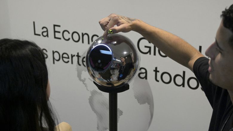 A woman has her iris scanned with an orb, a biometric data scanning device, in exchange for the Worldcoin cryptocurrency in Buenos Aires on March 22, 2024. In recent months, hundreds of thousands of Argentines have stood in front of a Worldcoin orb to scan the iris of their eyes in inflation-hit Argentina, where recent tightening delivered the coup de grace. The Worldcoin cryptocurrency, with a verification system based on iris recognition and launched in July 2023 by OpenAI CEO Sam Altman, is being closely watched by regulators in several countries due to data protection concerns.