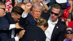 TOPSHOT - Republican candidate Donald Trump is seen with blood on his face surrounded by secret service agents as he is taken off the stage at a campaign event at Butler Farm Show Inc. in Butler, Pennsylvania, July 13, 2024. Donald Trump was hit in the ear in an apparent assassination attempt by a gunman at a campaign rally on Saturday, in a chaotic and shocking incident that will fuel fears of instability ahead of the 2024 US presidential election.
The 78-year-old former president was rushed off stage with blood smeared across his face after the shooting in Butler, Pennsylvania, while the gunman and a bystander were killed and two spectators critically injured. (Photo by Rebecca DROKE / AFP) (Photo by REBECCA DROKE/AFP via Getty Images)