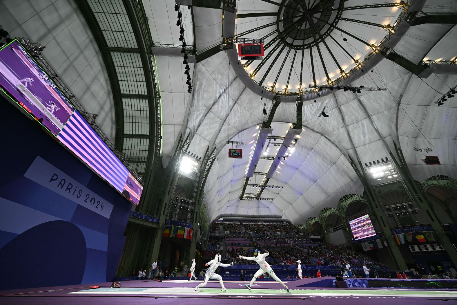 Japanese fencer Miho Yoshimura, left, competes against Rwanda’s Tufaha Uwihoreye in an épée round-of-64 bout on July 27. The Grand Palais, an exhibition hall and event center located off the Champs-Élysées, <a href="https://www.cnn.com/sport/live-news/paris-olympics-news-2024-07-31#h_7a865772de8a4cef656aa98d306ec05c"