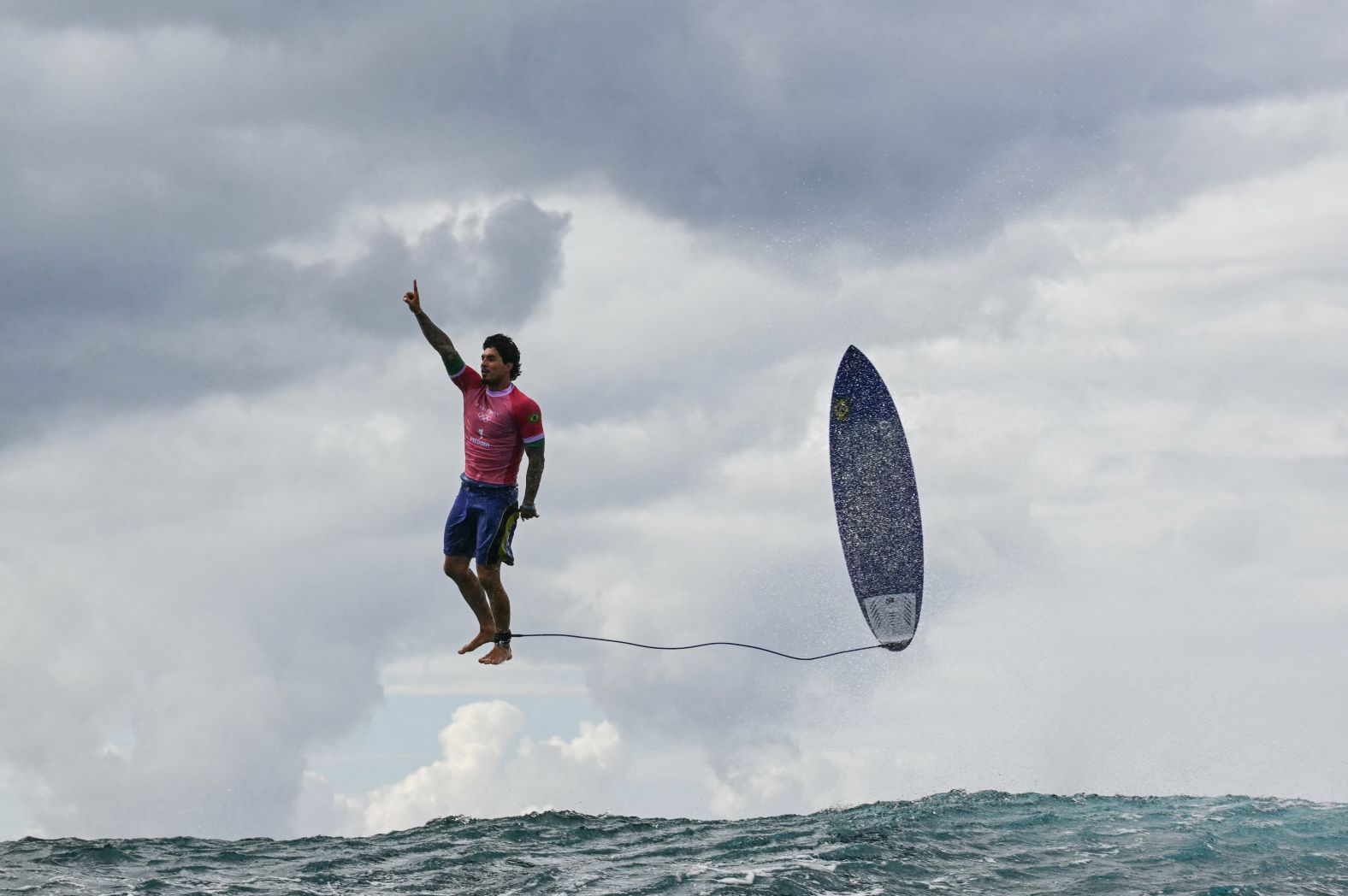 Brazilian surfer Gabriel Medina leaps from his surfboard and raises his finger in the air as he celebrates <a href="https://www.cnn.com/2024/07/30/sport/gabriel-medina-surfer-photo-paris-olympics/index.html"