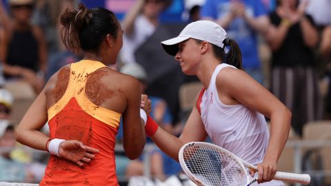 Winner, China's Zheng Qinwen (L) shakes hands with Poland's Iga Swiatek (R) after their women's singles semi-final tennis match on Court Philippe-Chatrier at the Roland-Garros Stadium during the Paris 2024 Olympic Games, in Paris on August 1, 2024. (Photo by Dimitar DILKOFF / AFP)