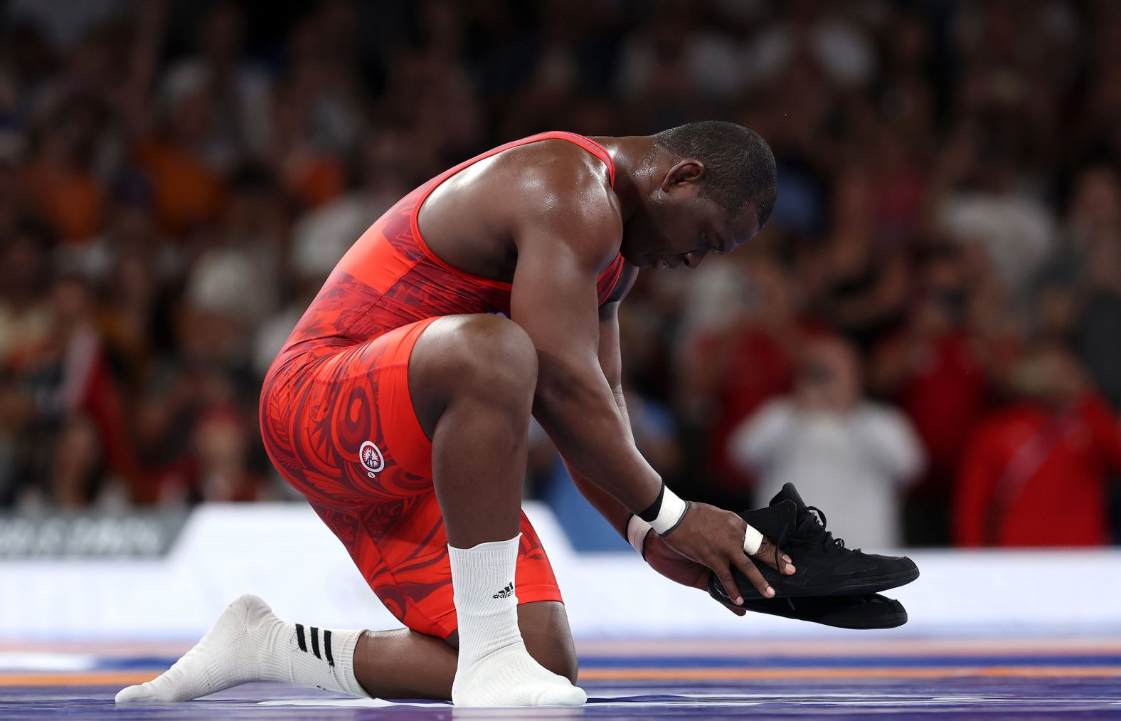 Cuban wrestling great Mijaín López leaves his shoes on the mat, signifying his retirement, after <a href="https://www.cnn.com/sport/live-news/paris-olympics-news-2024-08-06#h_5a21493bb1425e3f42c25fd5ac99f27a"