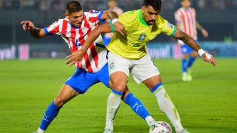 Paraguay's defender Juan Caceres and Brazil's midfielder Lucas Paqueta fight for the ball during the 2026 FIFA World Cup South American qualifiers football match between Paraguay and Brazil at the Defensores del Chaco stadium in Asuncion, on September 10, 2024.