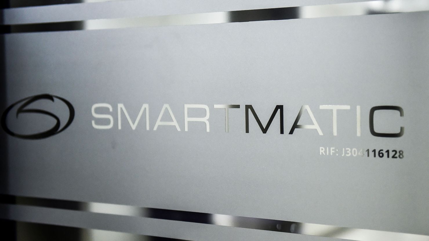 Picture of the logo of Smartmatic, the firm that supplies Venezuela's voting technology, seen on a sliding door at the headquarters of the company in Caracas on August 2, 2017.