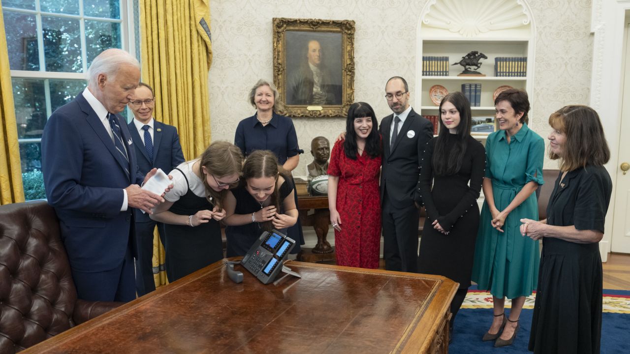 This photo posted to X.com by US President Joe Biden shows Biden and the families of detainees released as part of a complex prisoner swap between Russia on the phone for the first time since they were released in the White House in Washington, DC, on August 1, 2024. (Editor’s note: The document in Biden’s hand has been obscured by the White House.)