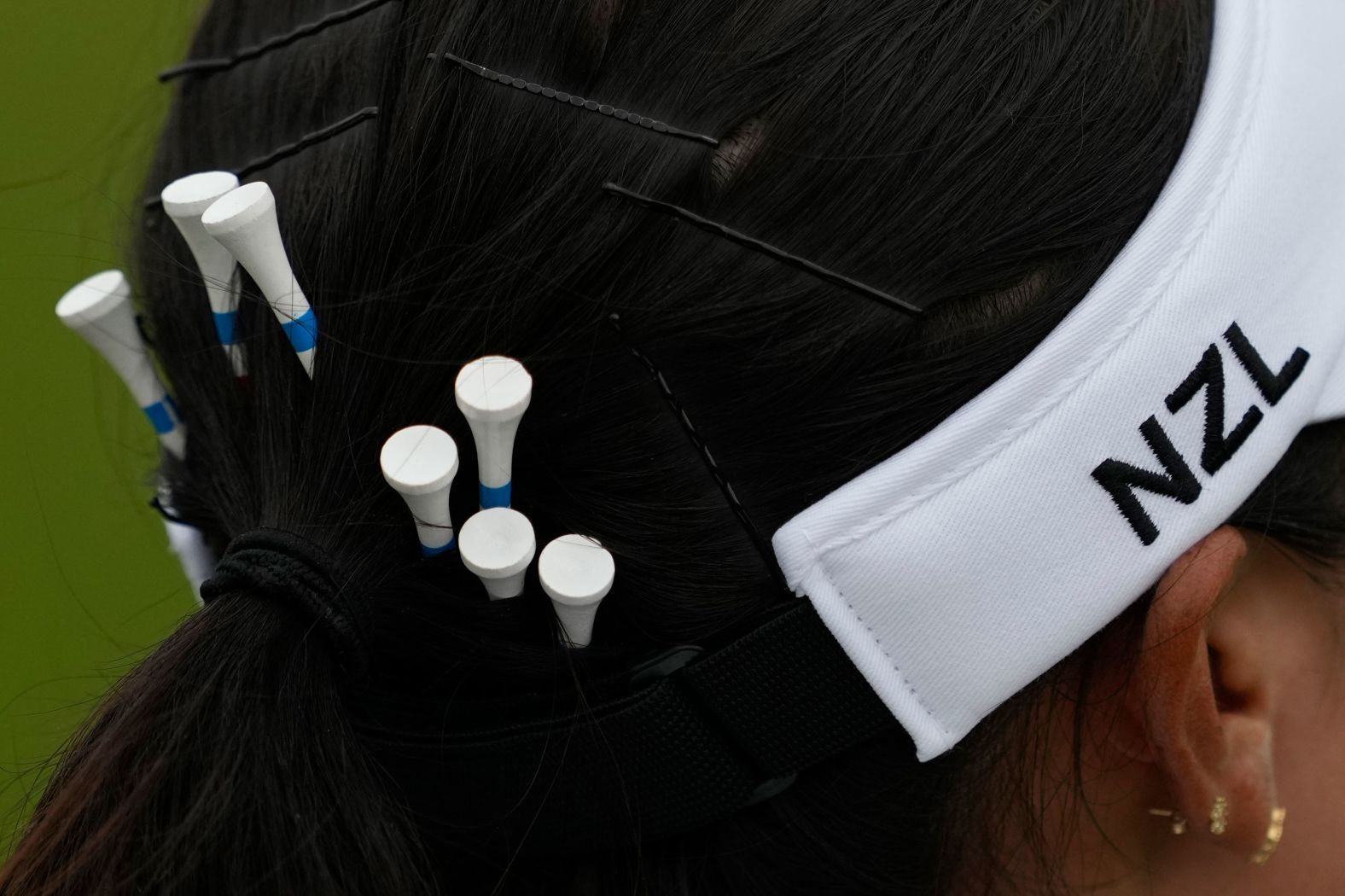 New Zealand's Lydia Ko carries spare tees in her hair during the third round of the women's golf tournament on August 9. Ko and Switzerland’s Morgane Métraux <a href="https://www.cnn.com/sport/live-news/paris-olympics-news-2024-08-09#h_9e0ee093e478c68c24e164409c7f6933"