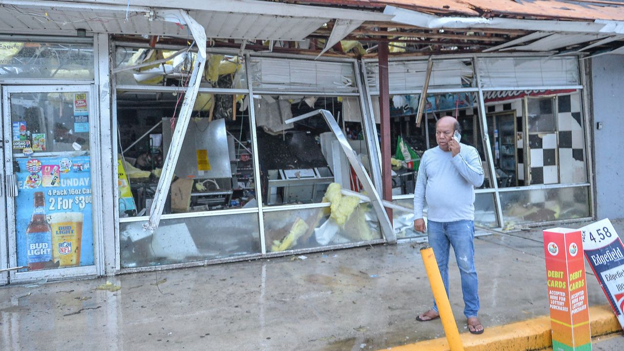 An owner of gas and convenience store along in Fort Pierce makes a call after a tornado cut through the area Wednesday, destroying the building as Hurricane Milton began to cross Florida.