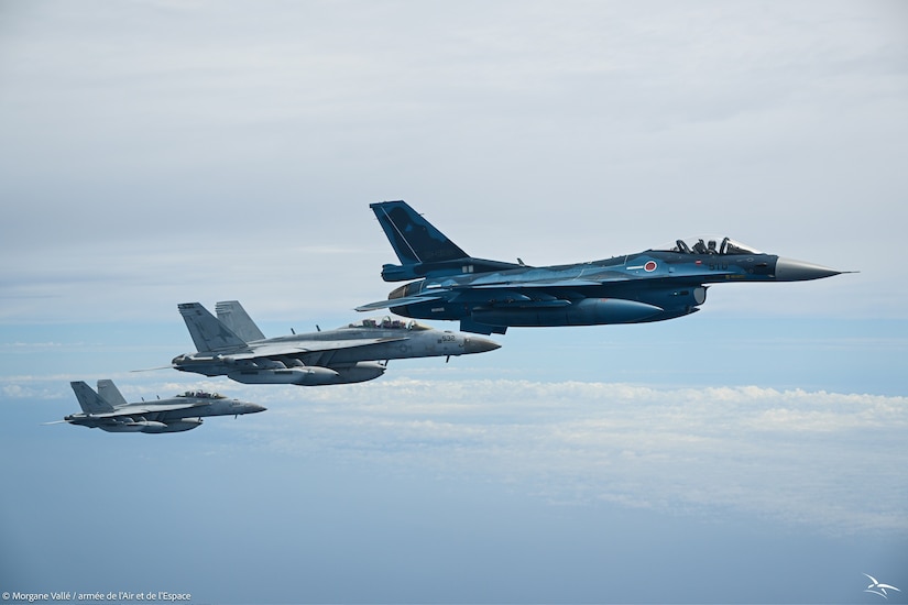 Three fighter jets fly one in front of the other in the sky.