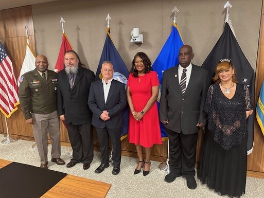 Five retirees stand with the Defense Logistics Agency Troop Support Commander for a photo