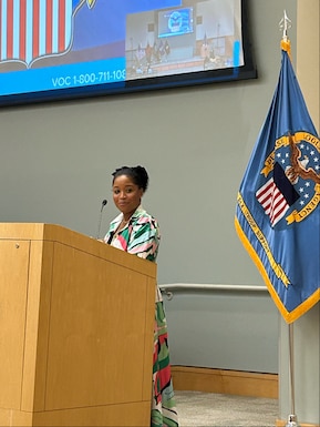 woman stands at podium