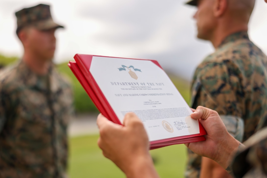 The Navy and Marine Corps Commendation Medal is presented to U.S. Marine Corps Cpl. Sean Olson, administrative specialist, Headquarters and Service Battalion, U.S. Marine Corps Forces, Pacific, during his meritorious promotion and award ceremony on Marine Corps Base Hawaii, Sept. 13, 2024. Olson, a California native, received the medal for rescuing two individuals who were struggling to stay afloat in rough waters, showcasing his exceptional dedication and performance as a Marine. He also earned a meritorious promotion, ahead of normal service requirements, signifying his outstanding performance as a Marine. (U.S. Marine Corps photo by Lance Cpl. Chloe Zimmerer)