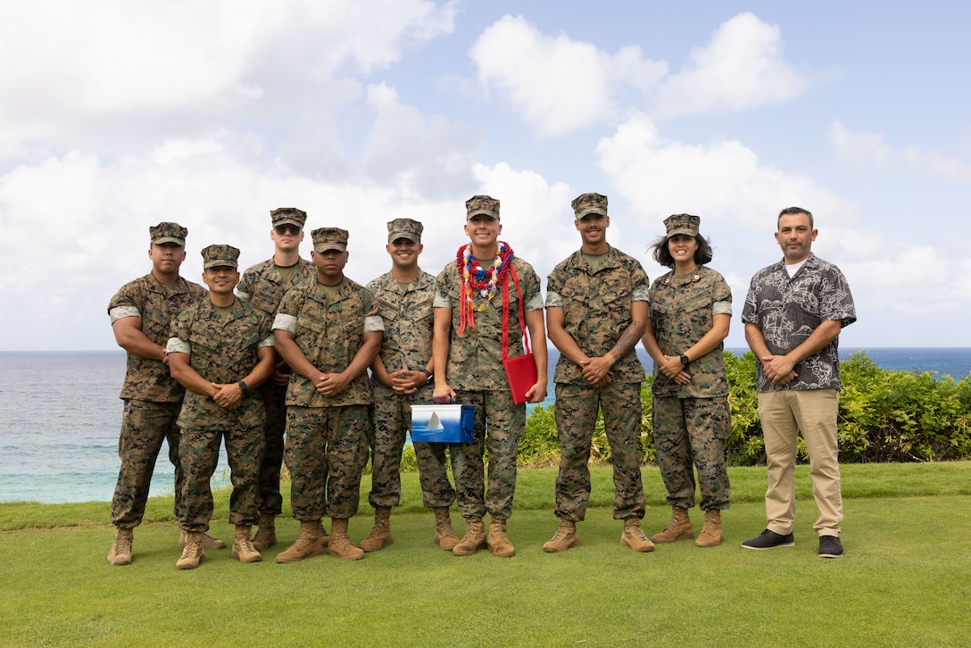 U.S. Marines from Headquarters and Service Battalion, U.S. Marine Corps Forces, Pacific, and a civilian pose for a group photo following Cpl. Sean Olson’s meritorious promotion and award ceremony on Marine Corps Base Hawaii, Sept. 13, 2024. Olson, a California native, received a Navy and Marine Corps Commendation Medal for rescuing two people who were struggling to stay afloat in rough waters. He also earned a meritorious promotion, ahead of normal service requirements, signifying his outstanding performance as a Marine. (U.S. Marine Corps photo by Lance Cpl. Chloe Zimmerer)