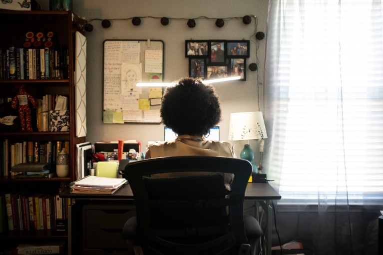 Genesis sitting at her desk with her laptop