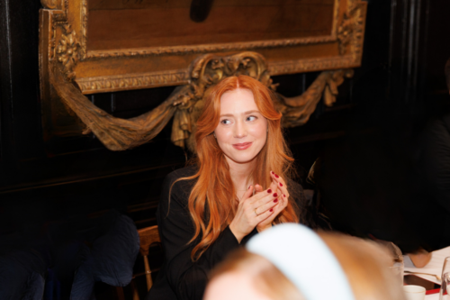 Woman smiling and clapping sitting down.