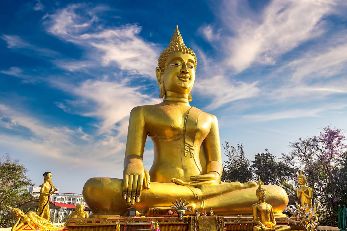 Bildet viser en stor gullstatue av Buddha som sitter med beina i kors.