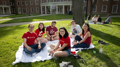 Alumni smiling together having a picnic during reunion. 