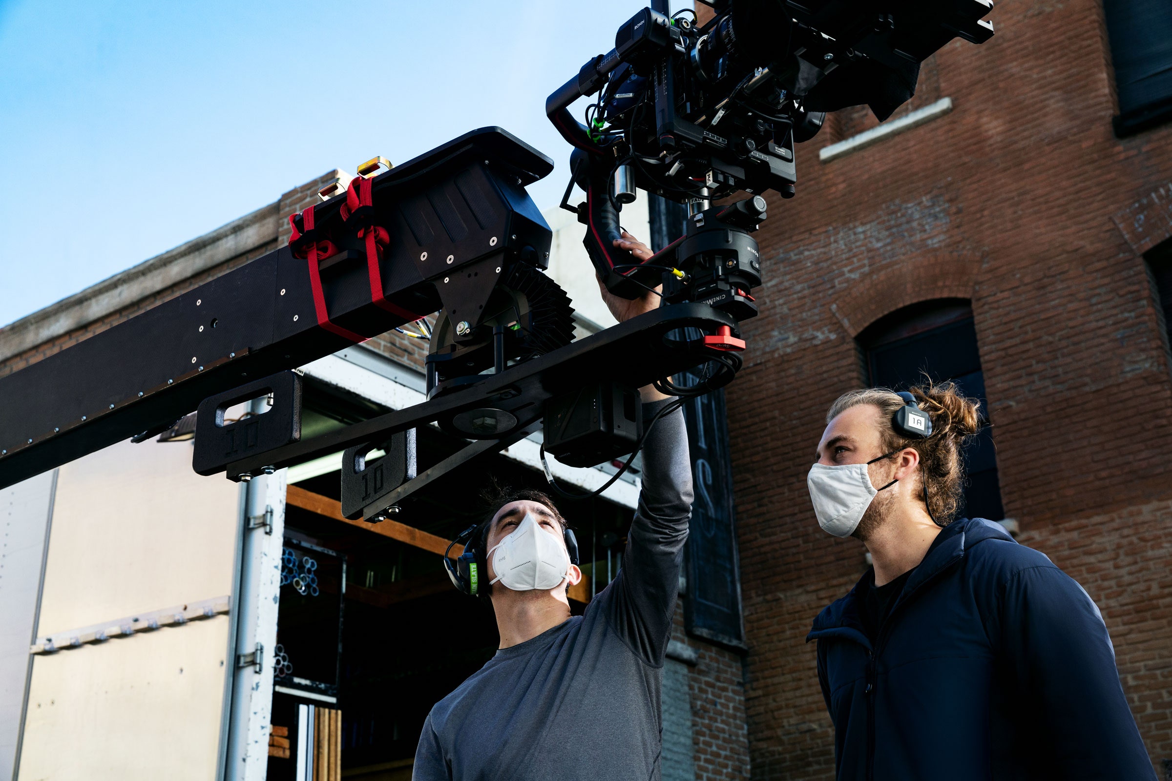 two filmmakers looking at a camera rig