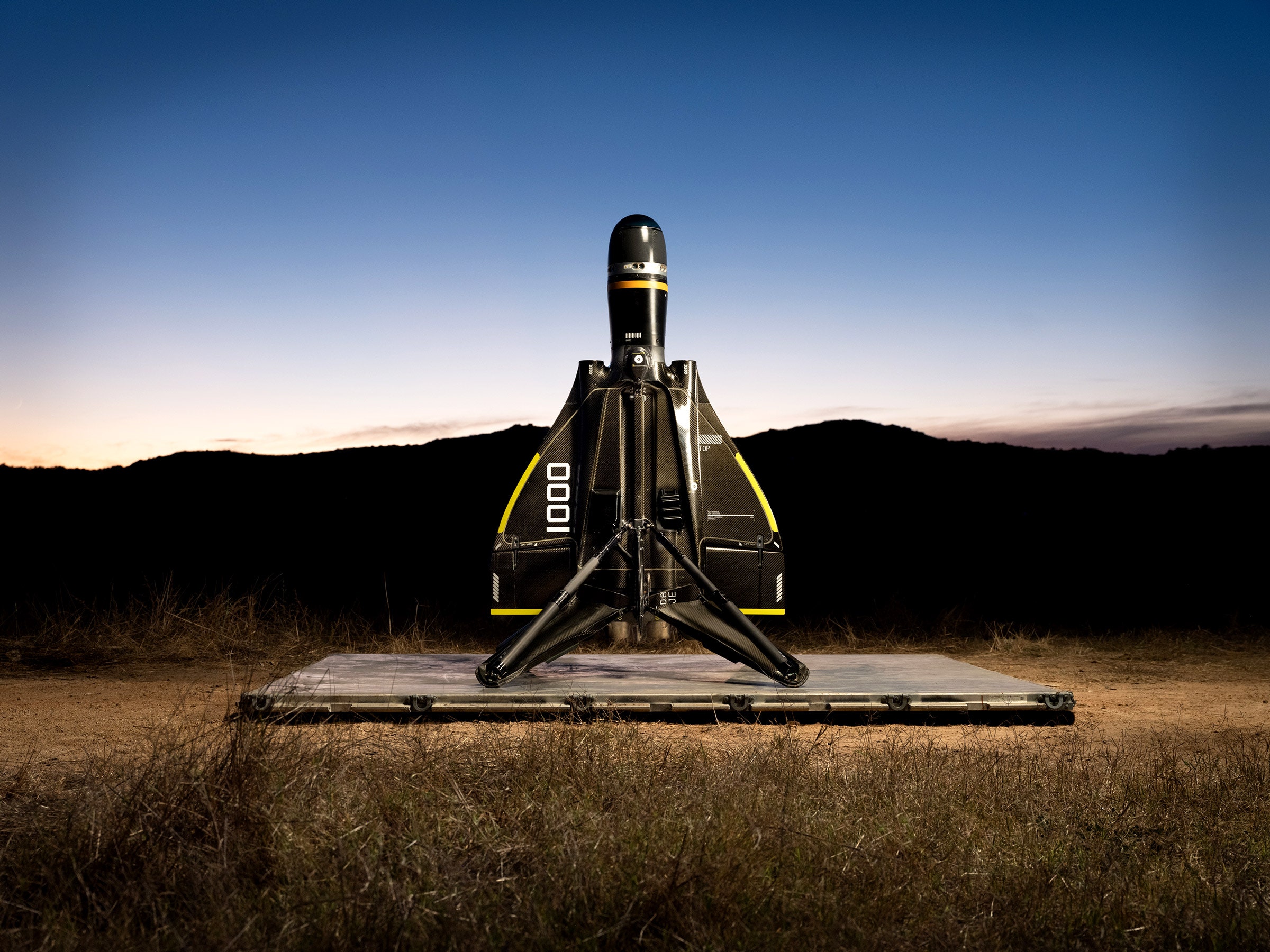 Anduril drone on a launch pad in a mountain landscape at dusk