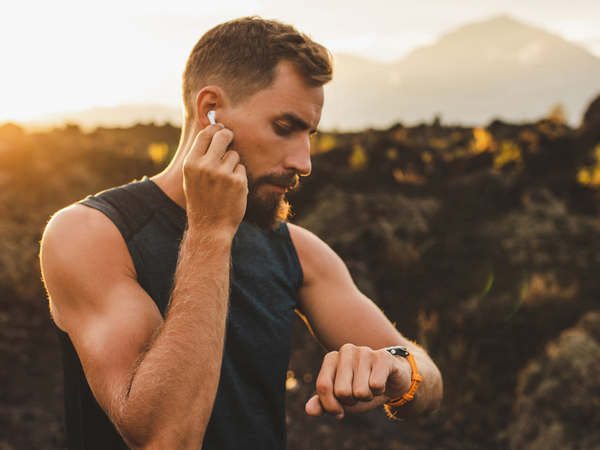 Quelqu'un se repose après son jogging tout en regardant sa montre connectée pour préchauffer le four en appuyant sur un seul bouton.