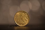 An Irish 20 cents of euro coin standing on a surface.