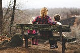 A mother with two children on a bench