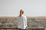 Young woman sitting on a split rail fence