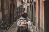 woman walking on street surrounded by buildings