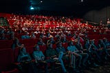 Movie theater full of people watching a movie