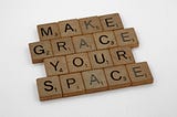 scrabble squares spelling “make grace your space”