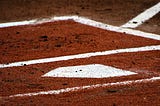 baseball home plate on reddish dirt