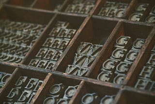 An old-fashioned type case containing upside-down and back-to-front upper case letters