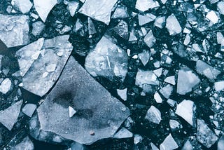 Flat shards of ice in dark water