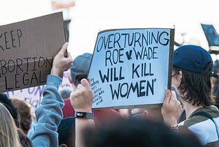 Pro-choice protest signs raised over the heads of demonstrators