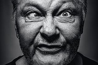 A Black & White Portriate of an older man making a funny face