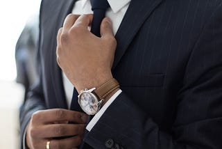 image of a man in a suit straightening his tie