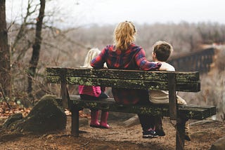 A mother with two children on a bench