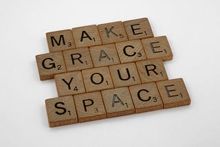 scrabble squares spelling “make grace your space”