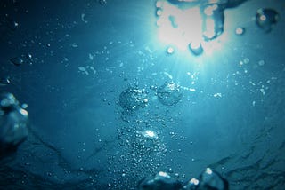 Sunlight viewed from underwater through bubbles.