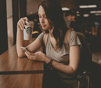 Girl texting friend at Starbucks