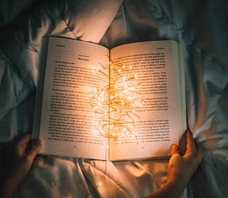 Boy reading a book full of light