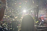 Back of child’s head staring at confetti in a dark arena