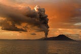 Volcano emitting smoke plume.