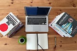 Philosophy books and Software Engineering books on a table with a laptop and notebook