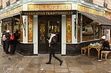 A Parisian woman hurries to work while patrons enjoy the simple yet delectable fare of morning coffee and fresh-baked bread at Du Pain et des Idées (Of Bread and Ideas), which has been lauded as one of the finest bakeries in Paris. Ensconced on a quiet corner in the 10th Arrondissemont, the bakery is housed in an authentic 1875 Beax-Arts storefront. (Photo: ©Craig K. Collins)