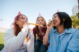 3 women with birthday hats on