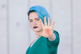 A women showing the feminism symbol on her hand.