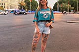 A woman stands in the road in Madrid, smiling.