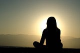 Woman meditating outdoors.