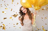 women holding balloons drinking Champaign to celebrate publishing her 200th article on medium