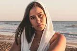 A women on the beach looking in the lens.